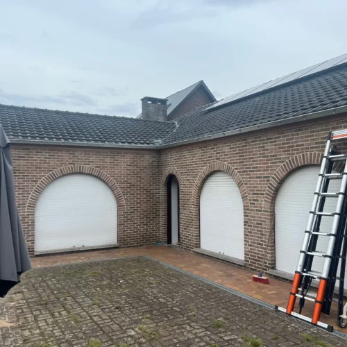Bakstenen woning met antracietkleurig pannendak rond een binnenkoer