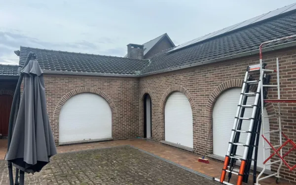 Bakstenen woning met antracietkleurig pannendak rond een binnenkoer