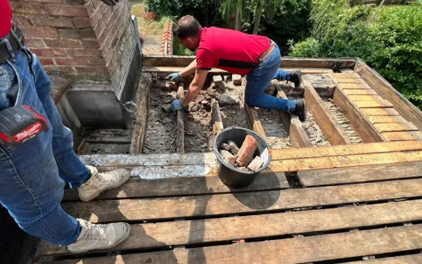 Afbraak van een oude dakrand bij de renovatie van een plat dak